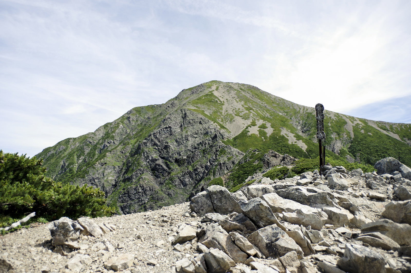 小聖岳から見た聖岳山頂への登山道、石積みと登山者が写る山岳風景
