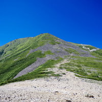 常念小屋から見る常念岳山頂方面の登山道と稜線の写真