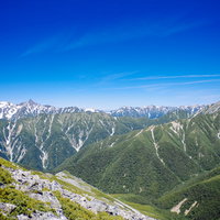 常念岳の山肌から見る槍ヶ岳方面の北アルプス連峰の写真