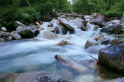 常念岳一の沢の白く流れる渓流と登山道、岩場と深緑の自然風景