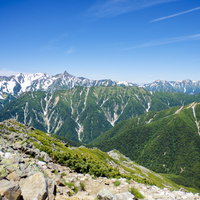 常念岳山頂から見る槍ヶ岳方面の北アルプスの山並みの写真