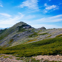 快晴の空の下、北アルプス表銀座登山道から見る常念岳の稜線の写真