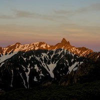 常念岳から望む朝日に燃える槍ヶ岳と北アルプスの雪山の写真