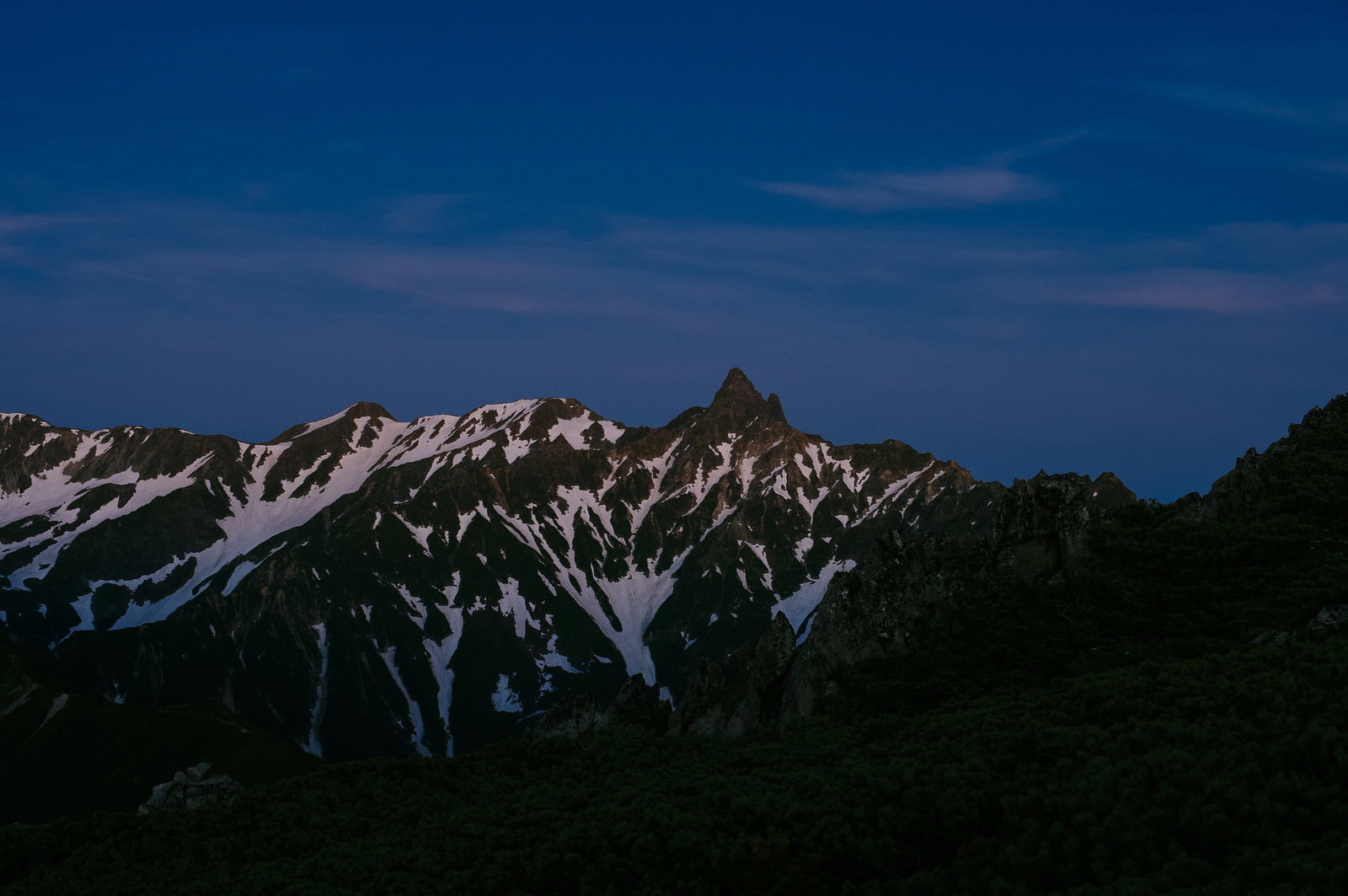 夜明けの空に浮かぶ雲と朝焼けに照らされ始める槍ヶ岳の山並み