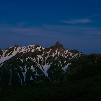 朝焼けに照らされ始める槍ヶ岳と常念岳の山並みの写真