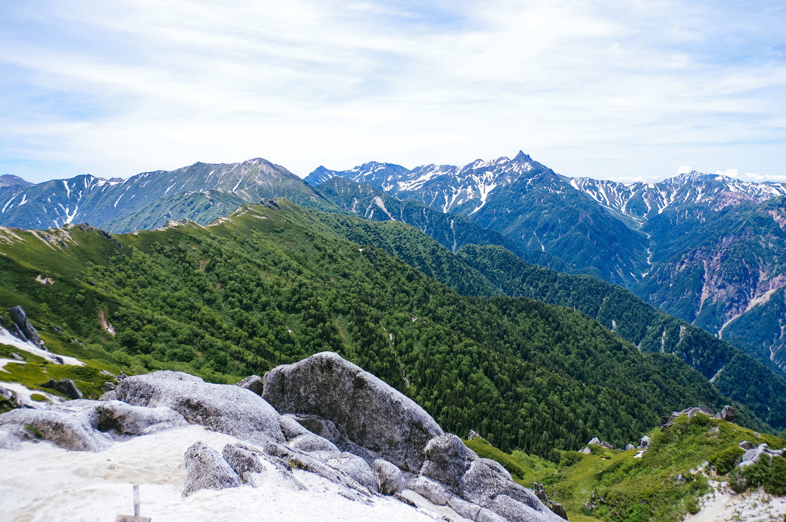 青空の下、緑の山々の向こうに聳える常念岳を燕岳から撮影した山岳風景