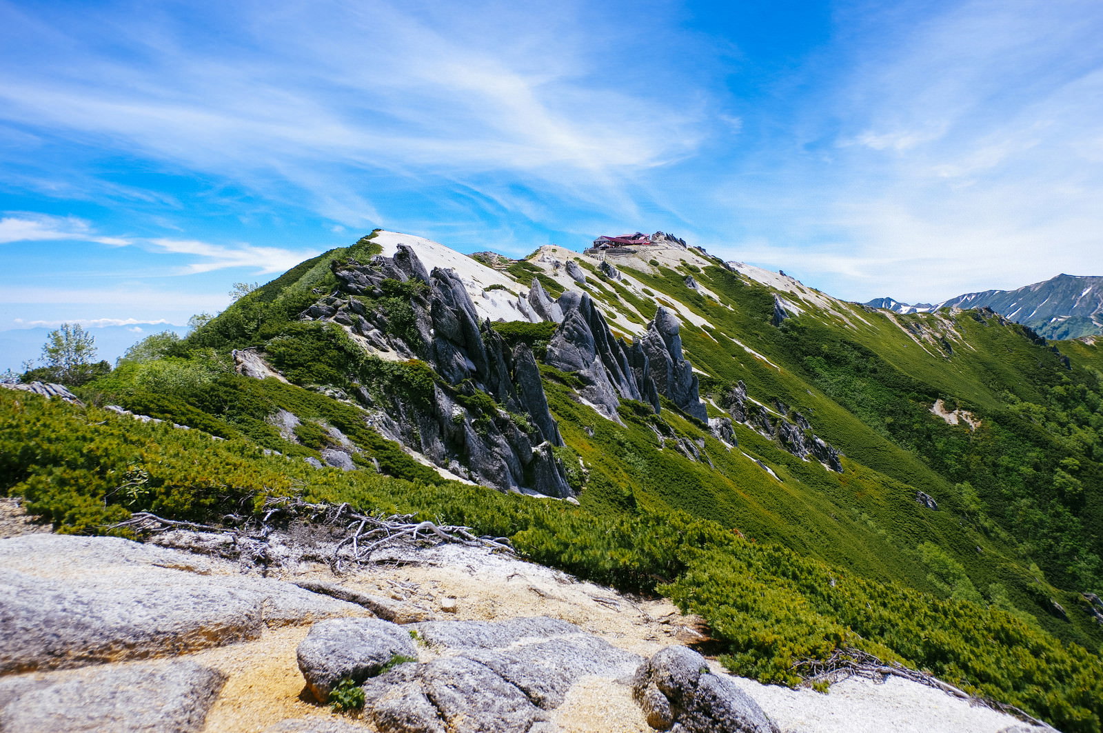 燕岳から見た常念岳と燕山荘方面の山岳風景、緑の稜線と青空
