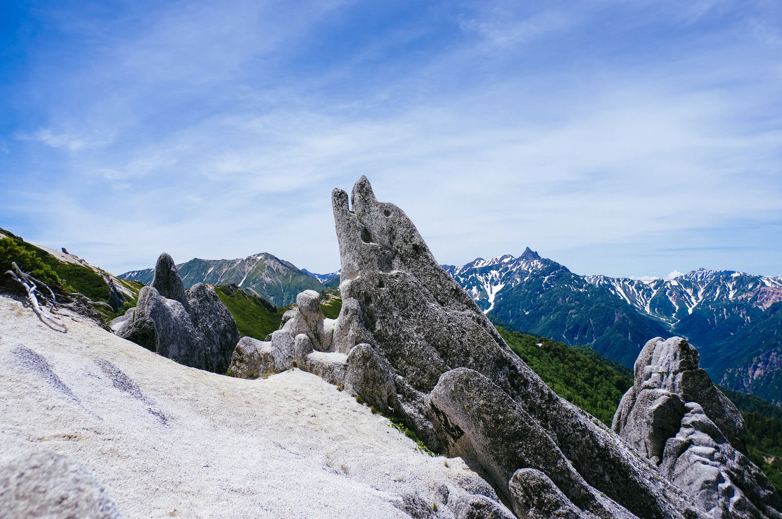 燕岳の特徴的なイルカ岩と常念岳の山並みが青空の下に広がる山岳風景