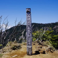 皇海山手前の鋸山の山頂碑と青空、登山道の景観の写真