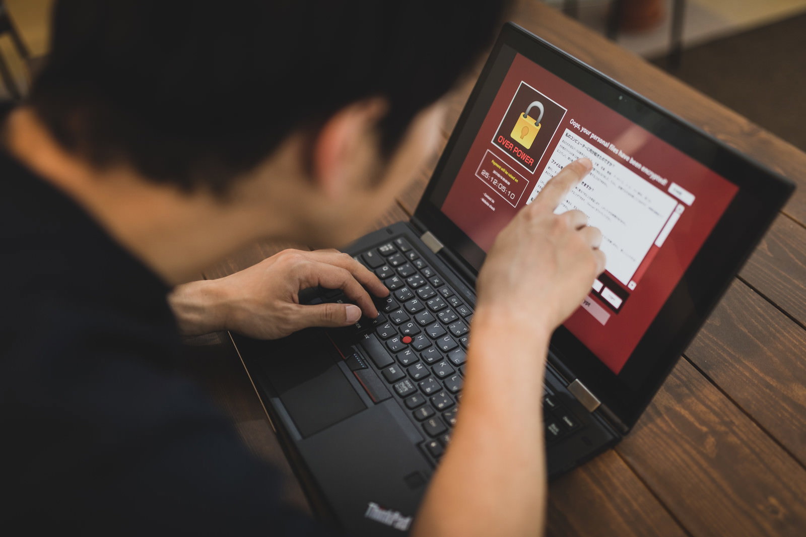 ランサムウェアに感染したPCを操作する男性［モデル：大川竜弥］