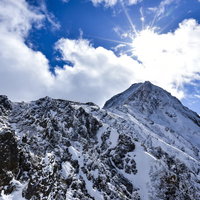 冬の地蔵尾根稜線側から見る雪山荘と山頂の絶景の写真
