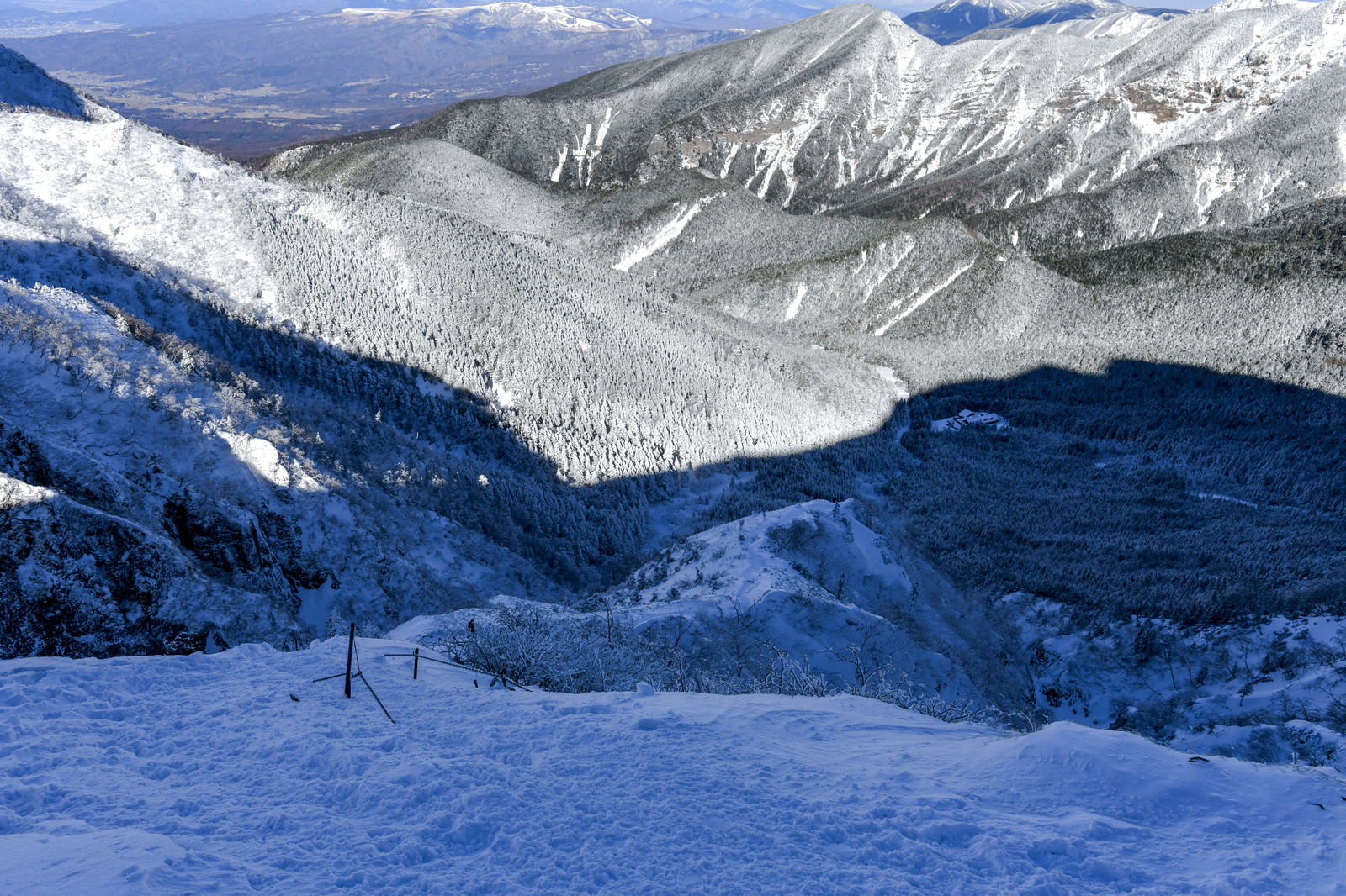 雪に覆われた文三郎尾根の登山道を上から見下ろした冬山の風景