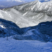 冬の八ヶ岳・文三郎尾根の登山道を見下ろす雪山の風景の写真