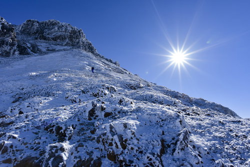 冬の文三郎尾根を登る登山者とピーカンの太陽