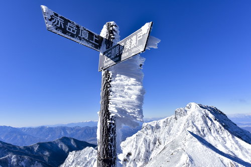 冬の北アルプス文三郎尾根稜線に立つ木製の指導標