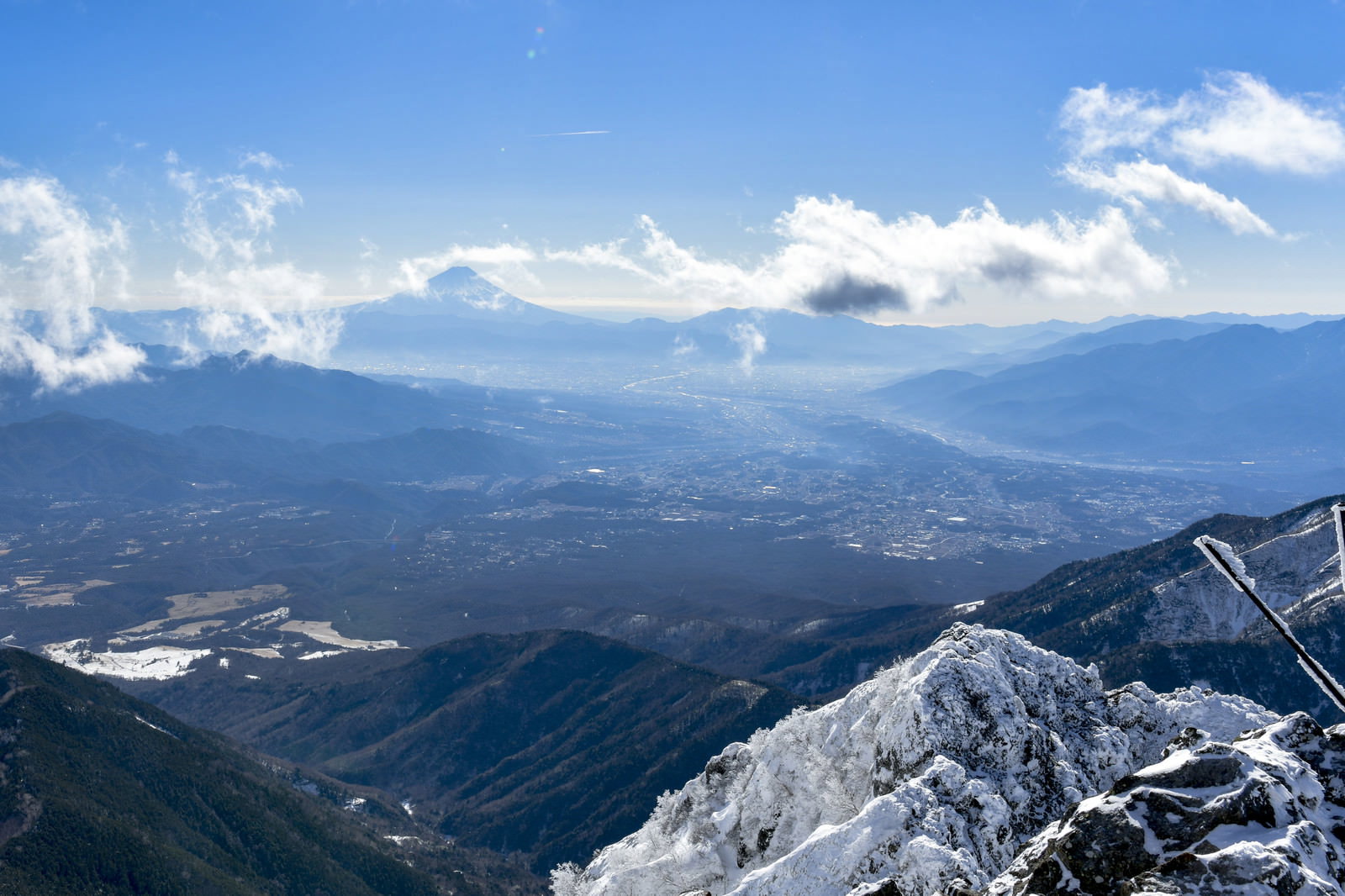 冬の赤岳山頂から眺める雪化粧した富士山と山々のパノラマ風景