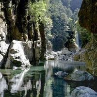 大杉谷シシ淵から流れ込む川に差し込む光と岩肌の写真