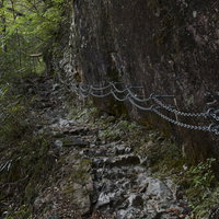 大杉谷の急峻な岩壁を登る安全装備の鎖の手すりの写真