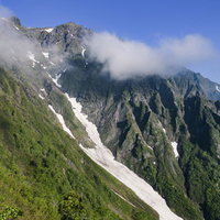 西黒尾根から眺める春の谷川岳山頂と残雪の稜線の写真
