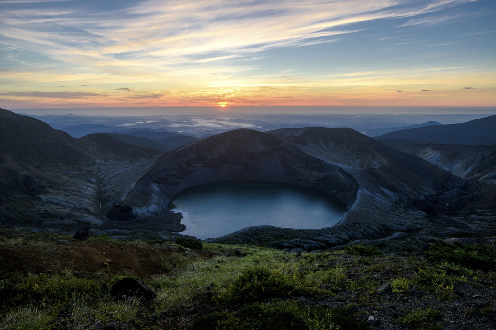 朝焼けに染まる蔵王お釜の火口湖と雲海が広がる山景色