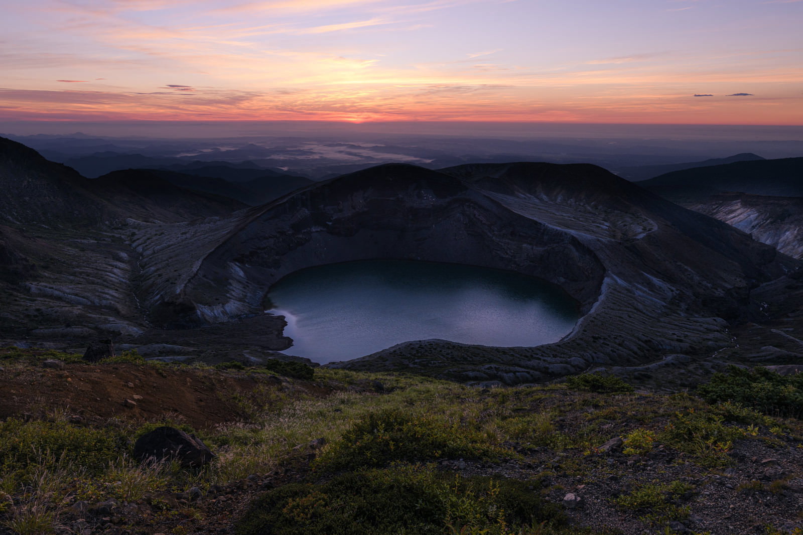 朝焼けの空の下に広がる蔵王のお釜火口湖と山々のシルエット