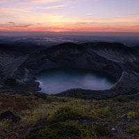真っ赤な空と蔵王のお釜、朝焼けに染まる火口湖の写真
