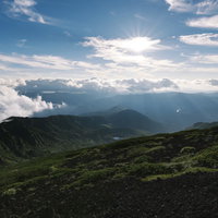 光差す裏岩手縦走路方面の山々と雲海の景色の写真