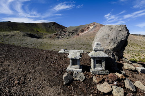 岩手山の山頂に建つ石造りの社と雲海の景色