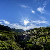 岩手山の不動平から見た光芒の太陽と山々の稜線の写真