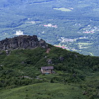 青空の下、平笠不動避難小屋と茶臼岳を望む岩手山の写真