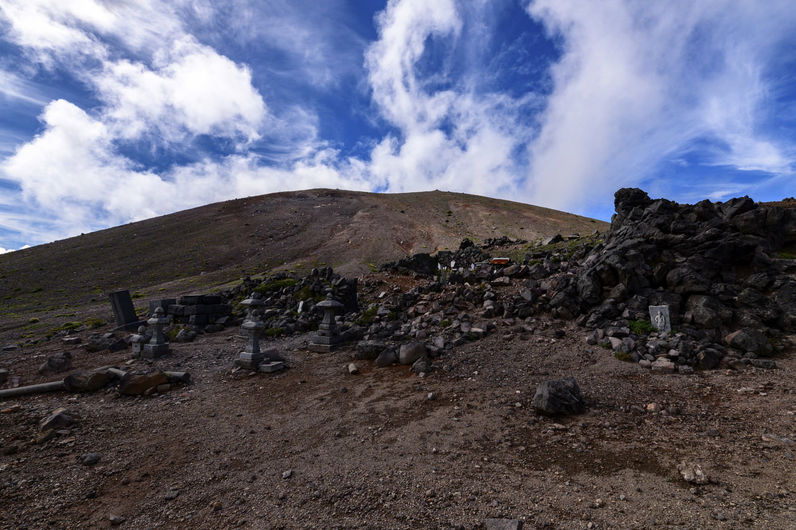 荒涼とした茶色の岩手山山頂付近に登山道が続く風景