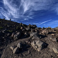 石と石碑が連なる岩手山のお鉢の山頂風景と登山道の写真