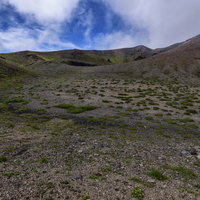 灰色の雲が漂う荒涼とした大地が広がる岩手山稜線の写真