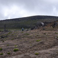 日本百名山・岩手山の荒涼とした山肌を歩む登山者たちの写真