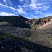 西日で立体感を強調する岩手山山頂の岩肌と植生の写真