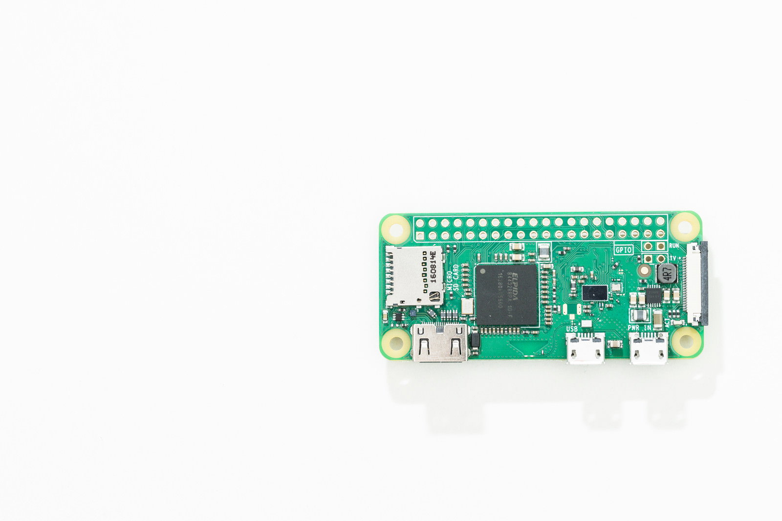 白い背景に置かれた緑色の小型パソコン（Raspberry Pi Zero W）