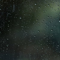 車窓のガラスに降り注ぐ雨と水滴が付着した車内からの景色の写真