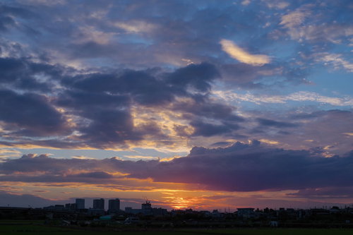 梅雨時の空に映る夕日と雲のグラデーション