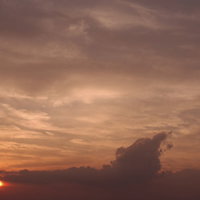 夕暮れの空を橙色に染める太陽の写真