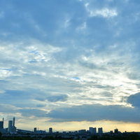 青々しい雲に覆われる新都心のビル群シルエットの写真
