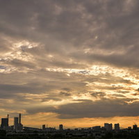 黄色く染まる梅雨時の新都心上空の雲と雲行きの写真
