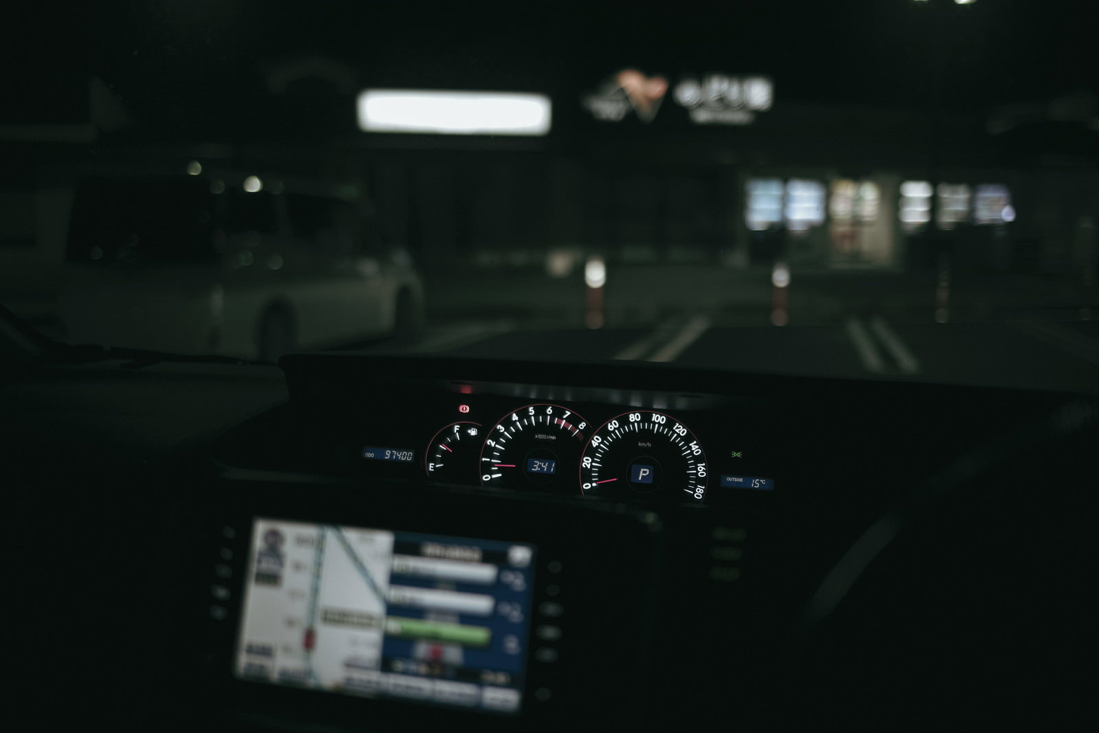 サービスエリアで夜間に撮影した車の運転席とメーターパネル