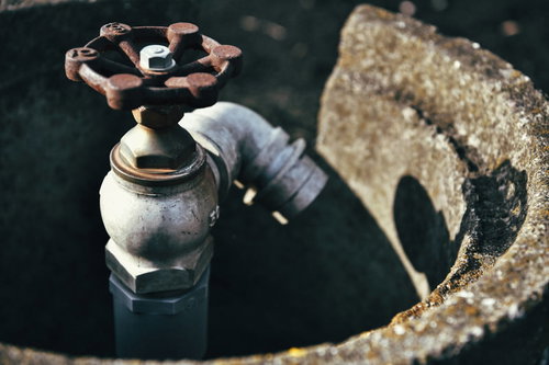 古い農水用の手動式ポンプとハンドバルブ、錆びた金属製