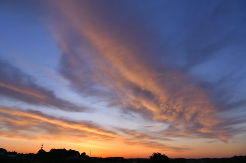 朝焼けに輝くオレンジの雲と早朝の空のグラデーション