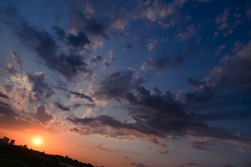沈みゆく太陽と荒れ狂う雲の夕景、地平線に映える夕焼けの風景