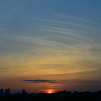 水色とオレンジに染まる空の夕日、グラデーション雲のシルエットの写真