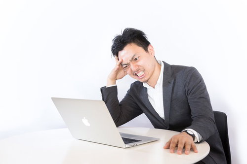 クレーマーの対処に頭を抱えるネットショップオーナー男性