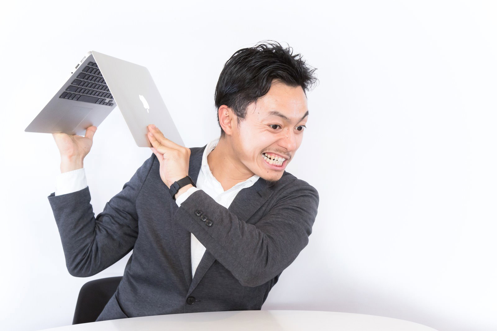 紙を投げつけて怒るスーツ姿の男性［モデル：藤沢篤］