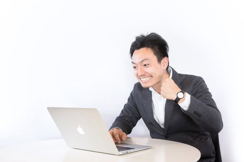 PC見ながらニヤニヤする男性