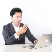 広告の配信が停止され収益が激減したブロガー、スマホでショックを受けるの写真